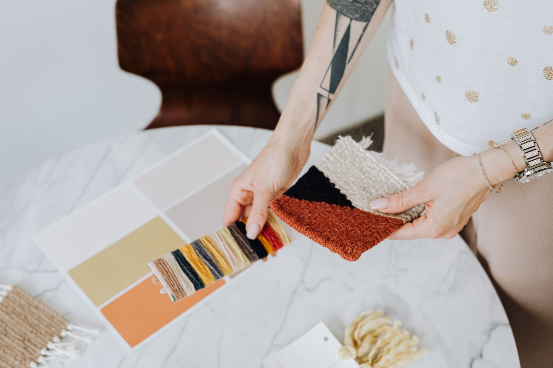 Fabric swatches, a colour palette and finish samples laid out on a table during scheme design
